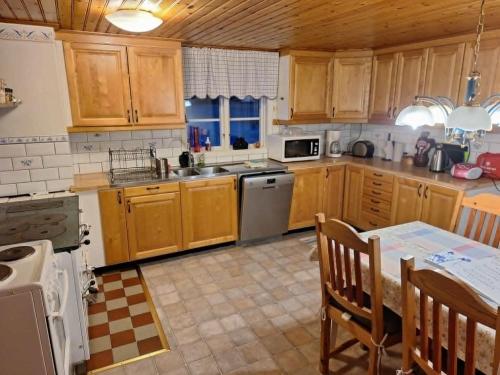 a kitchen with wooden cabinets and a stove top oven at Norsnäs Tempelbacken in Rengsjö