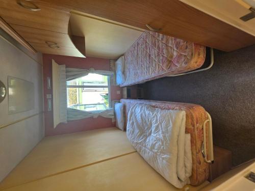 a small room with two bunk beds and a window at Twin Ayre Cabin Retreat Welshpool in Welshpool