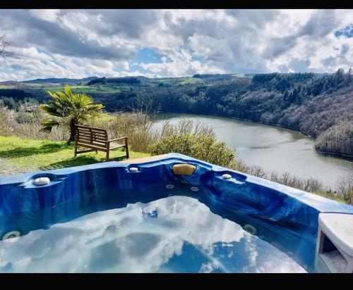 a blue bath tub with a view of a river at Yourte en bord Loire avec plage privée in Saint-Jean-Saint-Maurice-sur-Loire