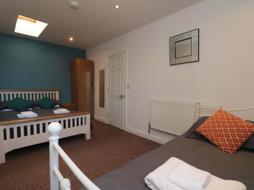 a bedroom with two beds and a tv on the wall at Farriers Cottage in Bridlington