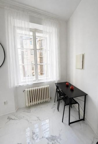 a white room with a black table and a window at Jela`s Suite in Vienna