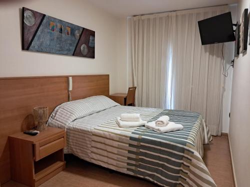 a hotel room with a bed with towels on it at Hotel venta de Tébar in Águilas
