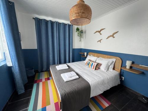 a bedroom with a bed with blue walls and birds at Pico Island Villas 117 - Natural Pools and Incredible Views in São Roque do Pico