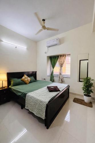 a bedroom with a bed and a ceiling fan at Deccan Homes Kondapur in Hyderabad