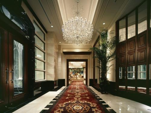 a hallway with a chandelier and a red carpet at Hotel La Suite Kobe Harborland in Kobe