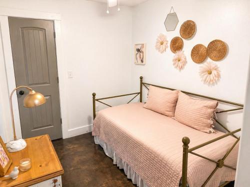 a bedroom with a bed with pink pillows and a table at Carriage House in Lufkin