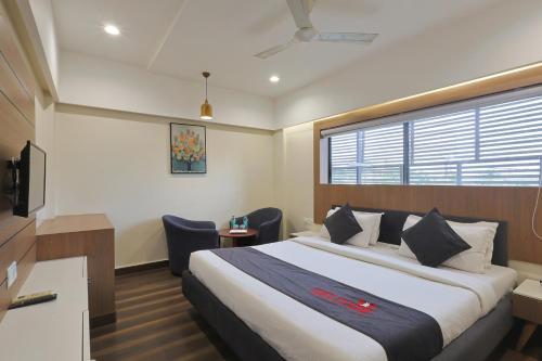 a hotel room with a large bed and a window at Hotel Vivanta Inn Somnath in Somnath