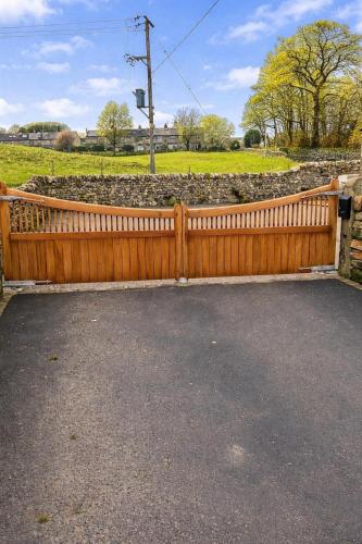 a wooden fence in front of a field at Ladywell Barn in Threshfield