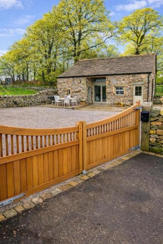 a wooden fence in front of a stone house at Ladywell Barn in Threshfield