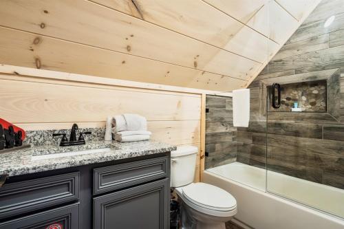 a bathroom with a toilet and a sink and a tub at Paradise Point in Pigeon Forge