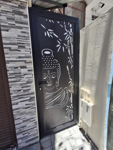 a door with a painting of a head on it at Cadets Studio in Mahébourg