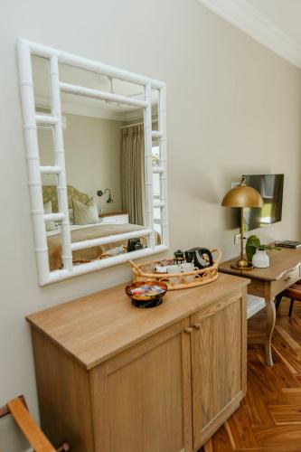 a room with a mirror and a table and a bed at Highlands House in Harare