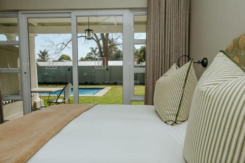 a bed with white sheets and pillows in a bedroom at Highlands House in Harare