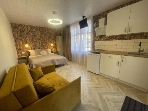 a room with a bed and a couch and a kitchen at Poilsiavietė Vita in Šventoji