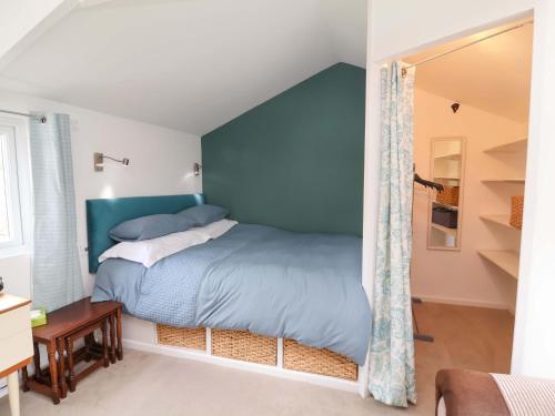 a bedroom with a bed with a blue wall at The Apple Loft in Exeter