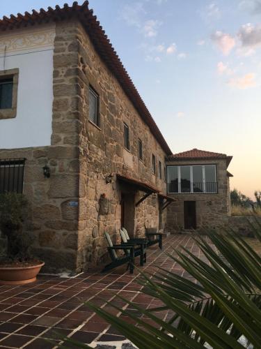 a stone building with two chairs on a patio at The Hideaway at Quinta de Moçamedes - Suites & Apartments in Vouzela