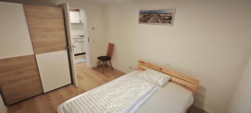 a bedroom with a bed and a door to a kitchen at Ferienwohnung ERSO in Wutöschingen