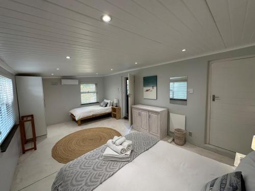 a large room with a bed and a room with a bed sqor at Spacious cottage with a private garden in Somerset West