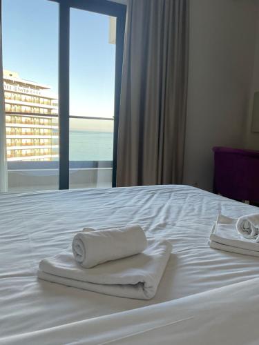 a bed with towels on it with a view of the ocean at Val Lux Apartmani in Sutomore