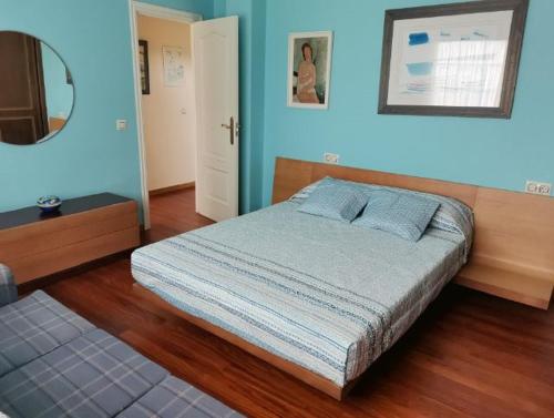 a bedroom with a bed with blue walls and a mirror at Casa Mar de Viladesuso in Oia