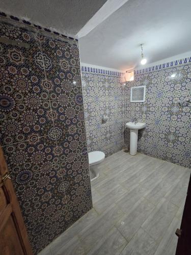 a bathroom with a toilet and a sink at Dunes Activity Camp in Mhamid