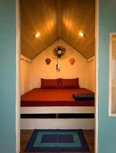 a small bed in a tiny house with a ceiling at Ayaan Beach Home in Dodanduwa