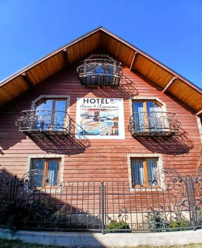 a building with balconies and a hotel sign on it at Карпатська Хата in Yasinya