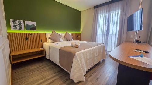 a hotel room with a large bed and a desk at Blue Tree Towers Millenium Porto Alegre in Porto Alegre