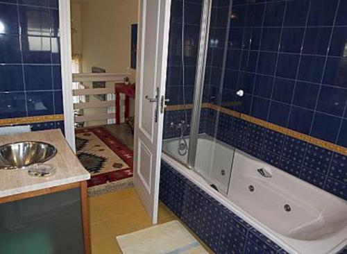a bathroom with a shower and a tub and a sink at Casa Mar de Viladesuso in Oia