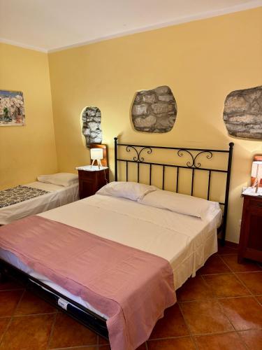 a bedroom with two beds and two windows at Casetta n.2 con piscina in Sarola