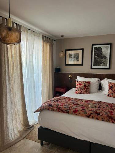 a bedroom with a bed and a large window at L'Intemporel in Saint-Cyr-sur-Mer