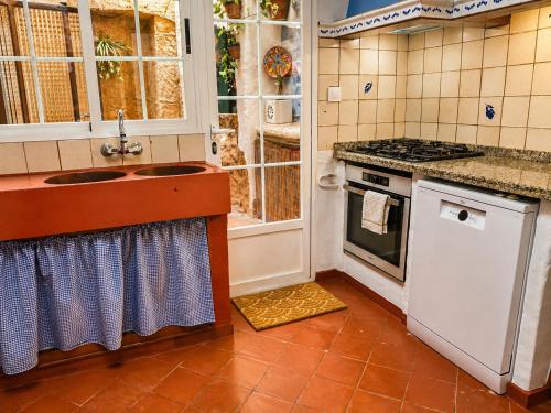 a kitchen with two sinks and a stove at La Rustiqueta Javea terraza BBQ casco antiguo in Jávea