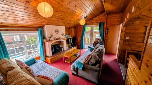 a woman sitting in a living room in a cabin at Cabin Gezellig in Trawsfynydd