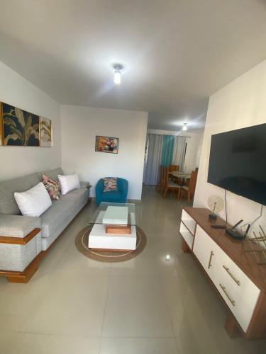 a living room with a couch and a flat screen tv at Estilo tropical 1 in La Romana