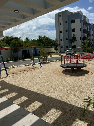 a playground with a red swing set in a building at Estilo tropical 1 in La Romana