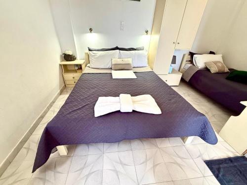 a bedroom with a purple bed with a bow tie on it at Xristinas Rooms in Lentas