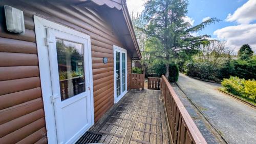 a front porch of a house with a white door at Cabin Gezellig in Trawsfynydd