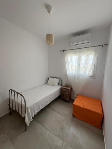 a small bedroom with a bed and a window at NAXIAN OLIVE House in Glinado Naxos