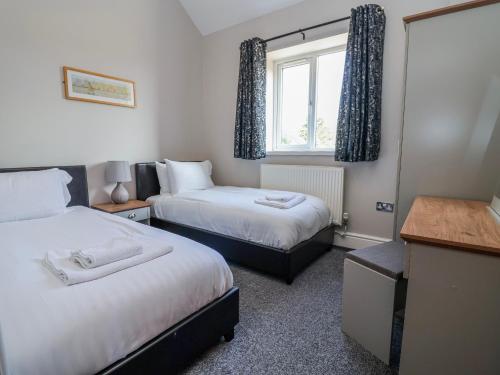 a hotel room with two beds and a window at Elwy Cottage in St Asaph