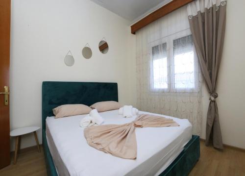 a bedroom with a bed with white sheets and a window at Jannas Home in Néa Karyá