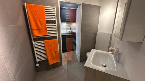 a bathroom with an orange towel rack and a sink at Bella-Lugano in Aldesago