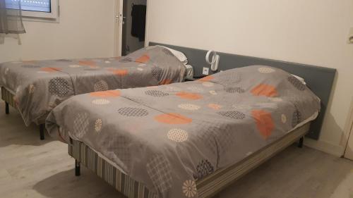 two twin beds in a hospital room with orange at Hôtel proche Cherbourg Hôtel l'Eden à Brix in Brix