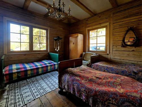 a bedroom with two beds and a chandelier at Gałęziówka, Doły Biskupie in Kunów