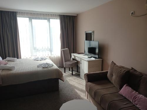 a hotel room with a bed and a couch at Hotel Kralj in Vrnjačka Banja