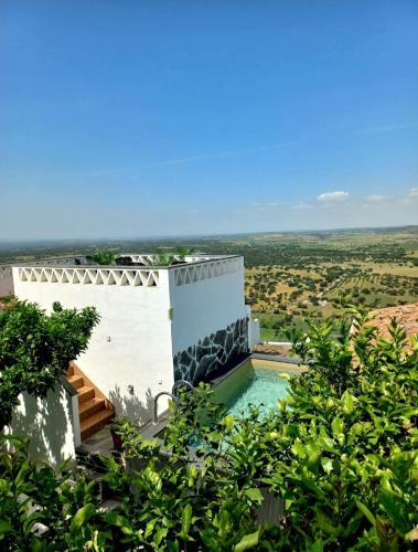 a villa with a swimming pool on a hill with a view at Casa Dona Antonia - Monsaraz in Monsaraz