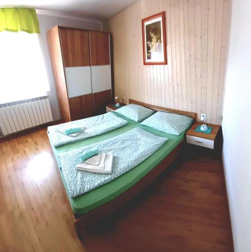 a bedroom with a green bed with shoes on it at Apartments Krn in Drežniške Ravne