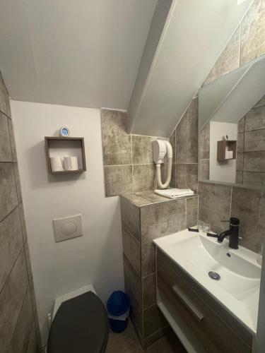 a small bathroom with a sink and a toilet at Hotel Des Bains in Veulettes-sur-Mer