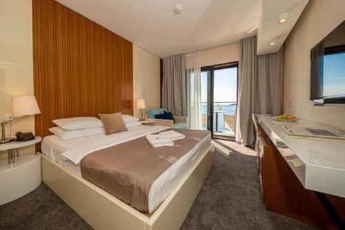 a hotel room with a large bed and a bathroom at Hotel Aleksandar Rafailovići in Budva