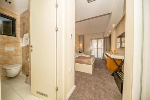 a bathroom with a bed and a sink in a room at Hotel Aleksandar Rafailovići in Budva