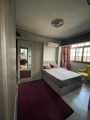 a bedroom with a large bed and a window at Dora home in Cairo